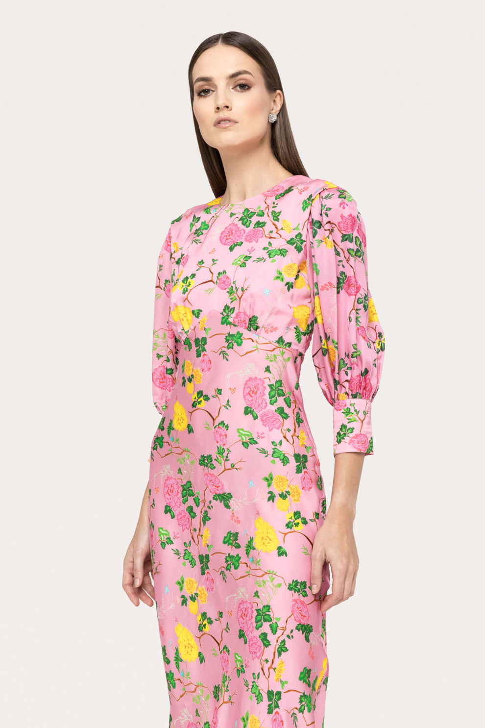 Close-up detailing the luxurious viscose fabric and vibrant yellow and green floral pattern on the pink Nissa midi dress.