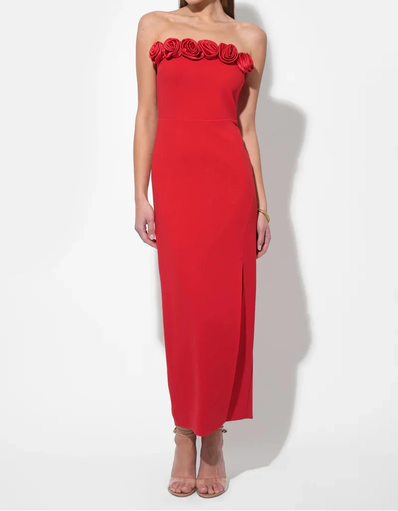 Woman wearing a red strapless dress with floral details on a white background