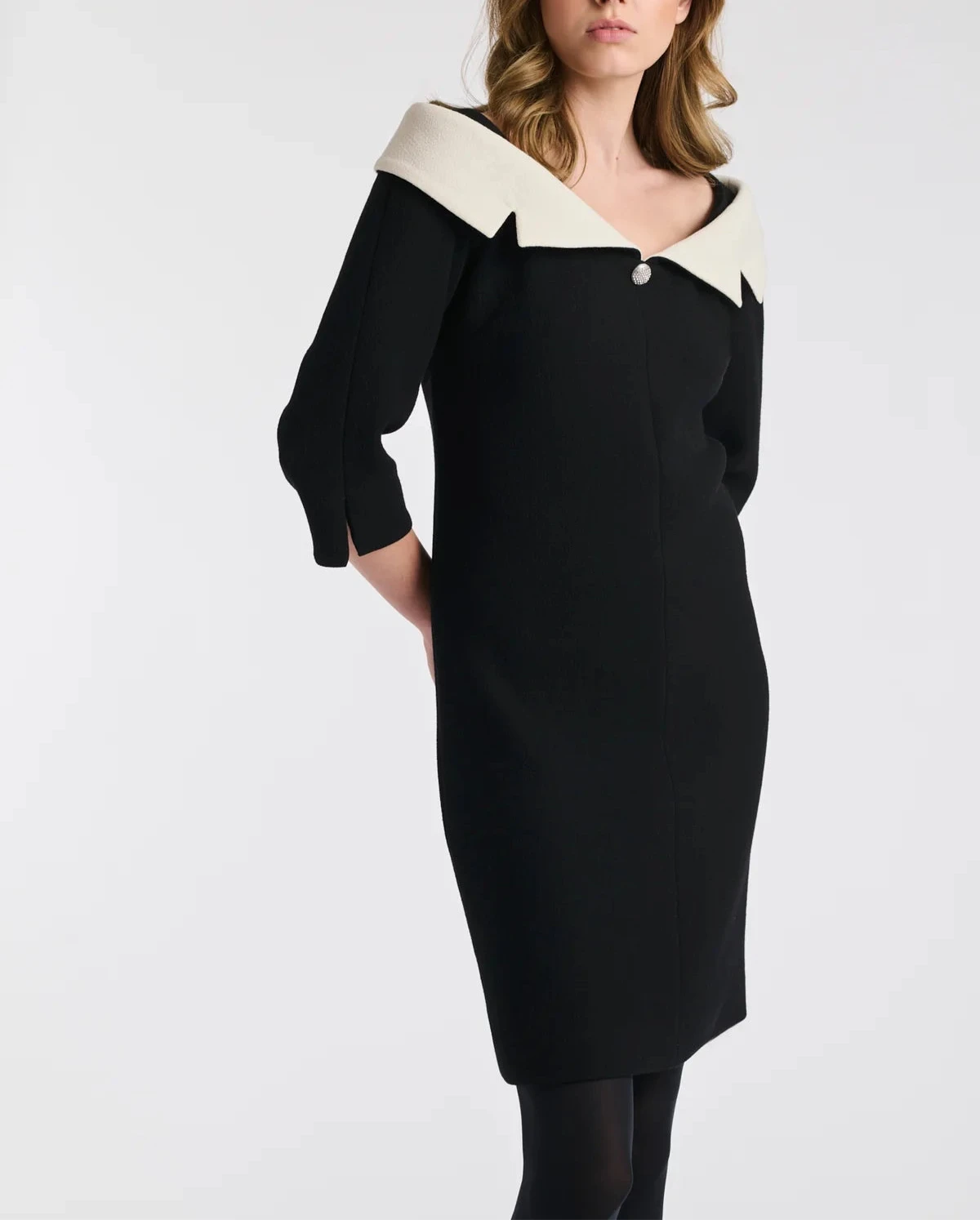 Close angled view of Weill Paris black sheath dress showing ivory Bardot neckline, tailored fit, 3/4 sleeves.