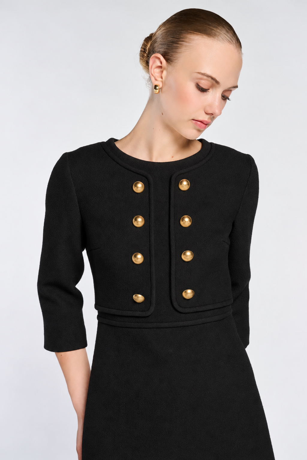 Close-up of gold-tone buttons, round neckline and matching black trim on the Weill illusion dress