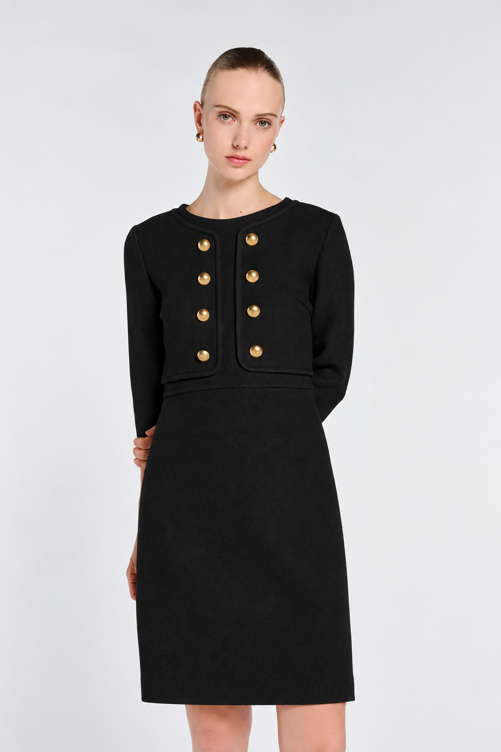 Front view of the black Weill dress showing its straight-cut silhouette, waist trim and gold-tone buttons