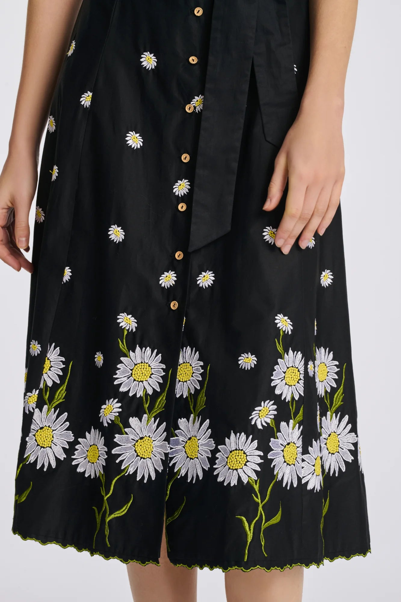 Close-up of black cotton midi shirt dress with floral embroidery along the hem
