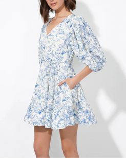 Model wearing Clare blue floral mini dress with pockets and v-neck – side view