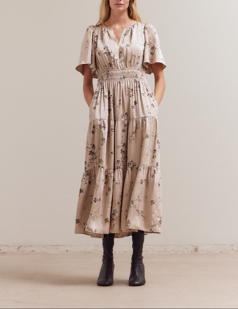 Walking view of natural floral tiered midi dress with pockets