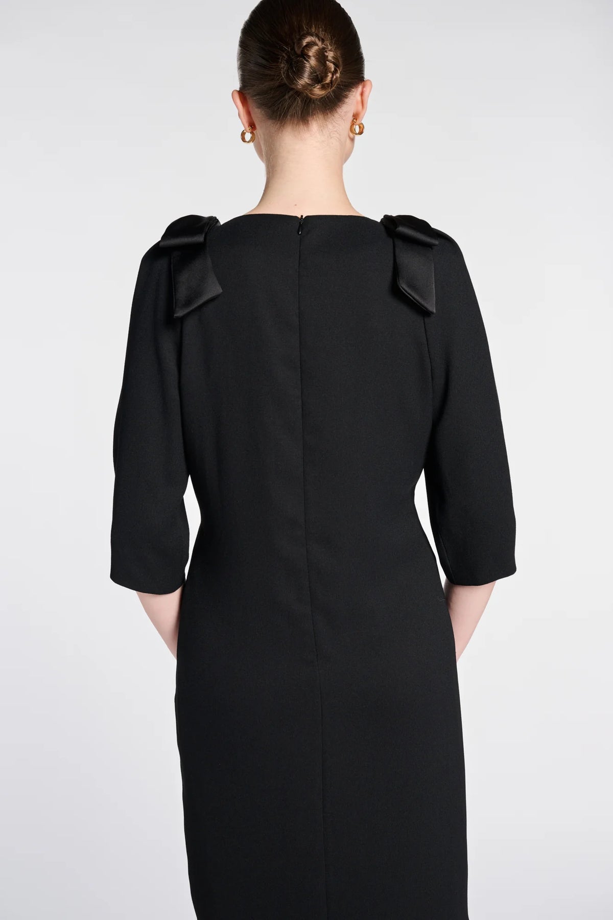 Close-up of the concealed back zipper and satin shoulder bows on WEILL Paris black cocktail dress.