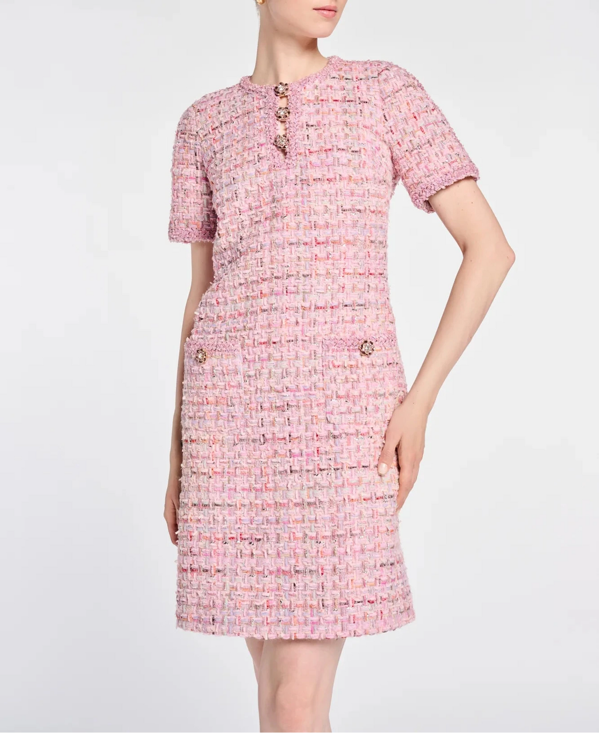 Three-quarter front view of a fitted Weill Paris pink tweed dress with braided trim and two patch pockets.