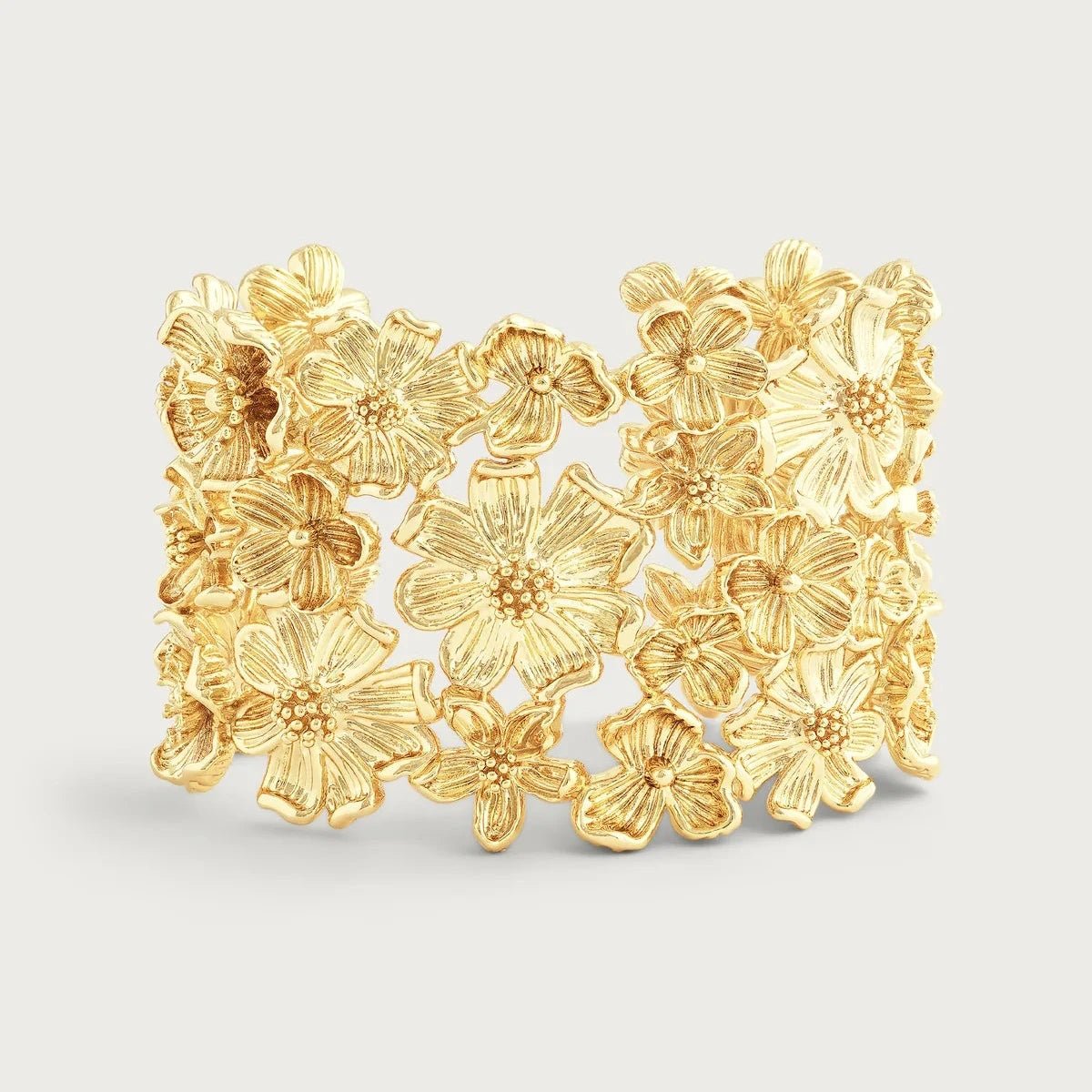 Wildflower‑inspired wide cuff bracelet by Anabel Aram with sculpted gold-tone flowers in an open cuff design