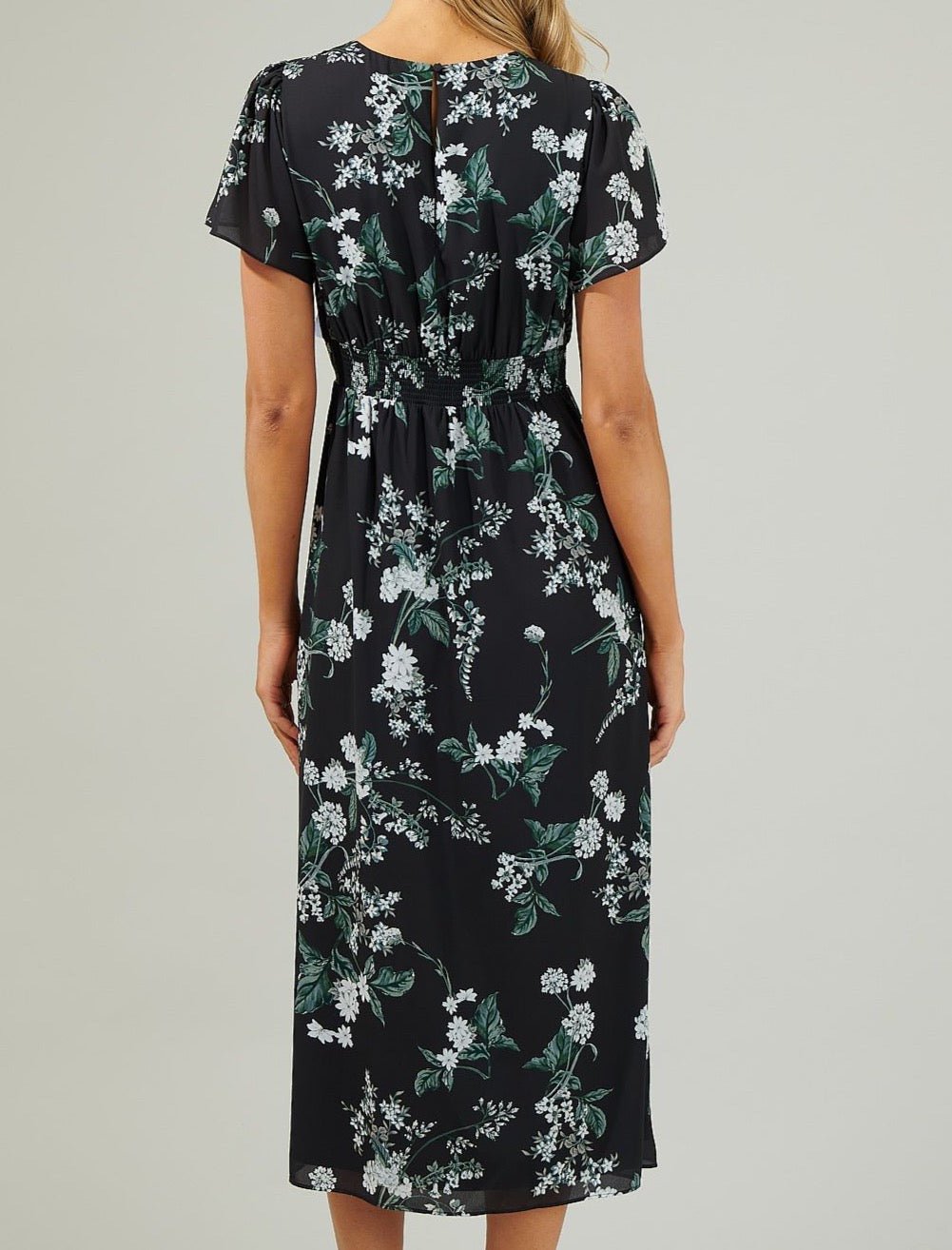 Back view of the Angelonia black floral midi dress showing the keyhole opening, smocked waistband and flutter sleeves.