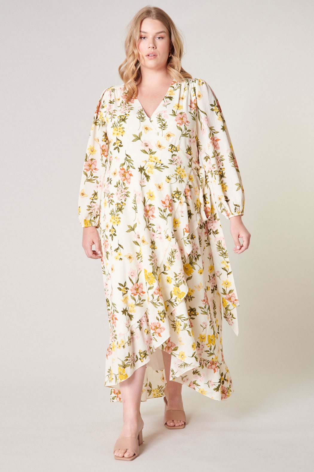 Plus size pastel floral wrap maxi dress with long sleeves and asymmetrical hem front view