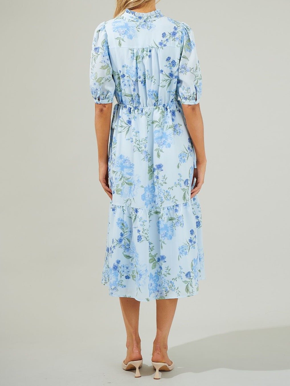 Back view of light blue floral midi dress with short puff sleeves and midi silhouette