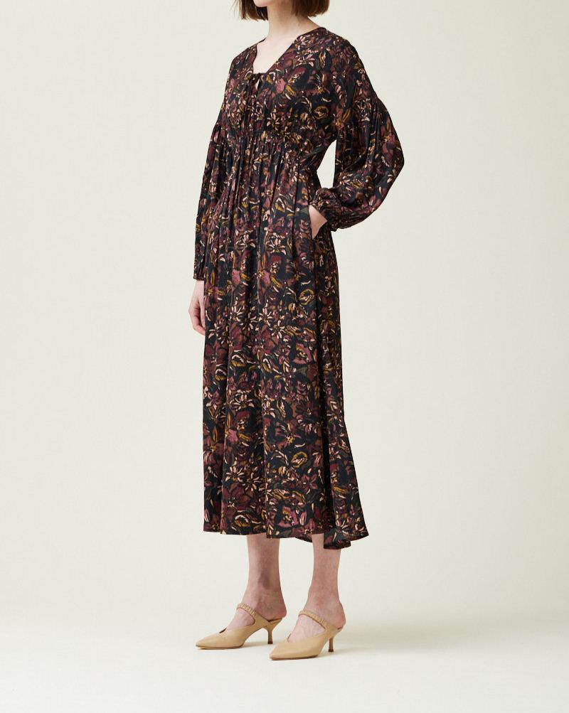 Angled side view of black floral printed satin midi dress with pockets