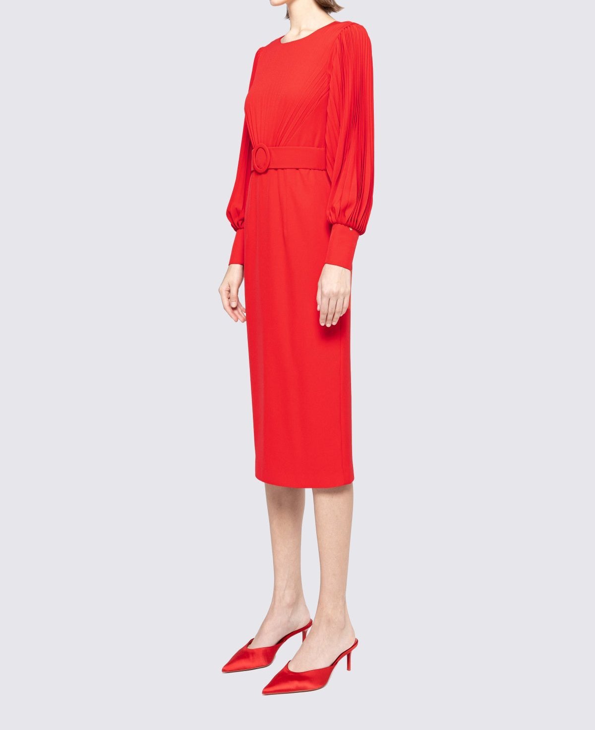 Side view showing slim pencil silhouette and pleated balloon sleeves on red long‑sleeve midi dress