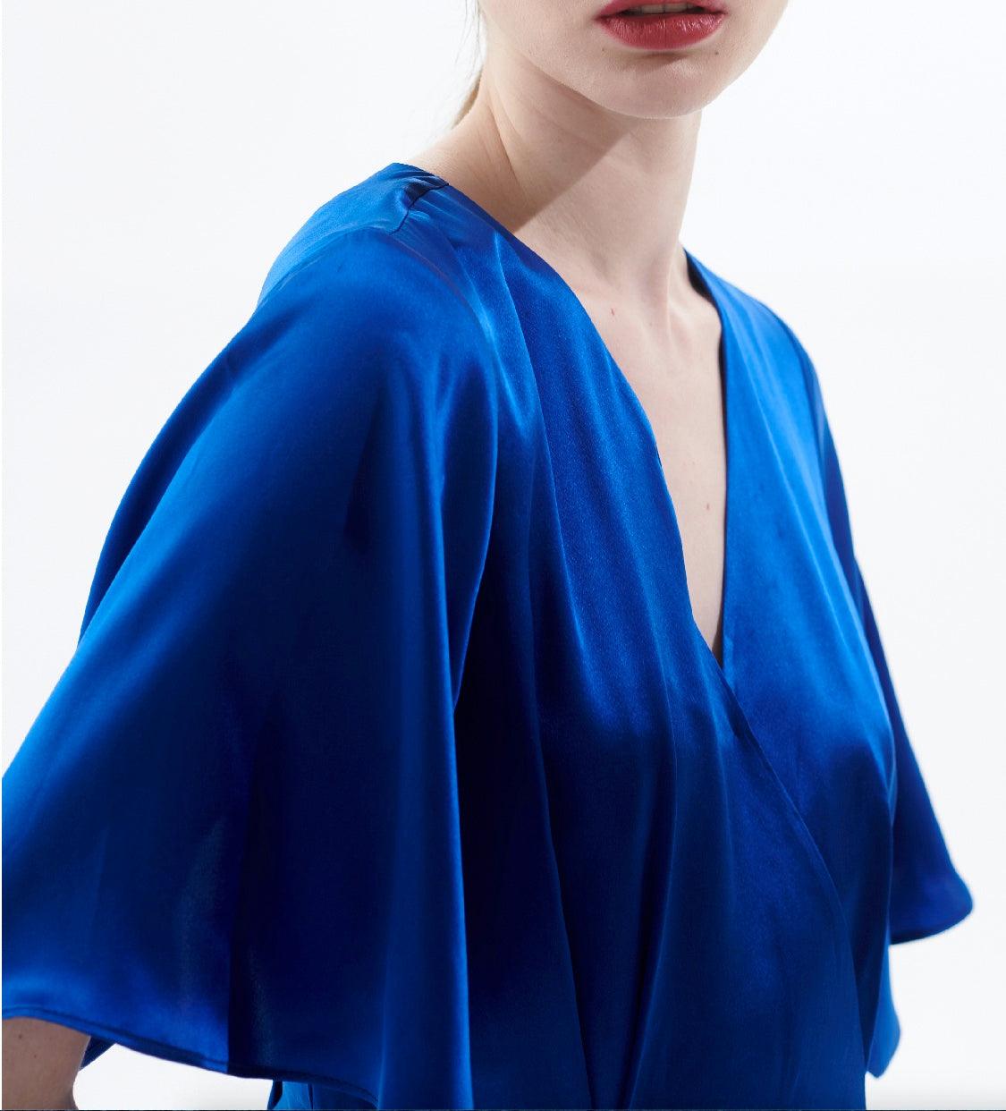 Close-up of smooth silk satin fabric in royal blue midi wrap dress