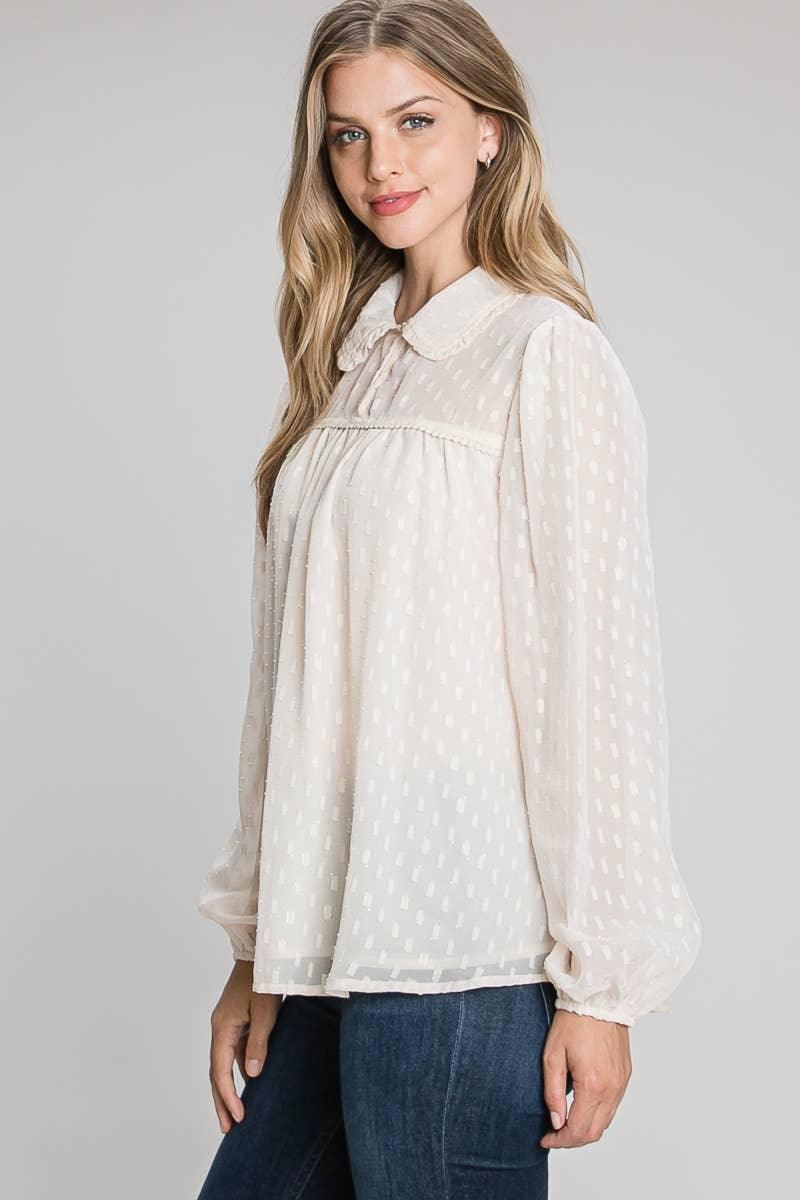 Angled view of the Champagne Allie Rose blouse showing its relaxed drape, geometric texture and elastic cuffs.