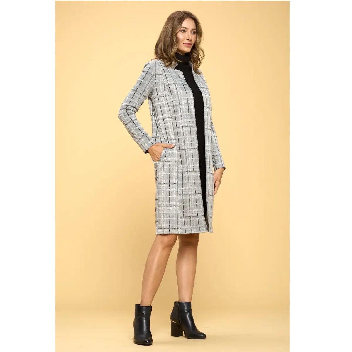 Angled view of Renee C grey plaid open-front longline jacket showing a side pocket, worn over a black dress.