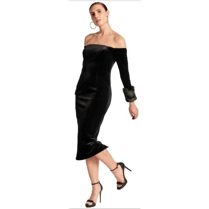 Angled full-length view of the Joia off-the-shoulder black velvet dress, showing its fitted silhouette and strappy heels.