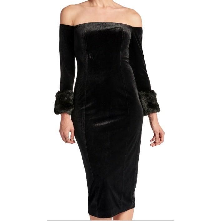 Close-up of the Joia black velvet dress showing the off-the-shoulder neckline, front princess seams and faux-fur cuffs.