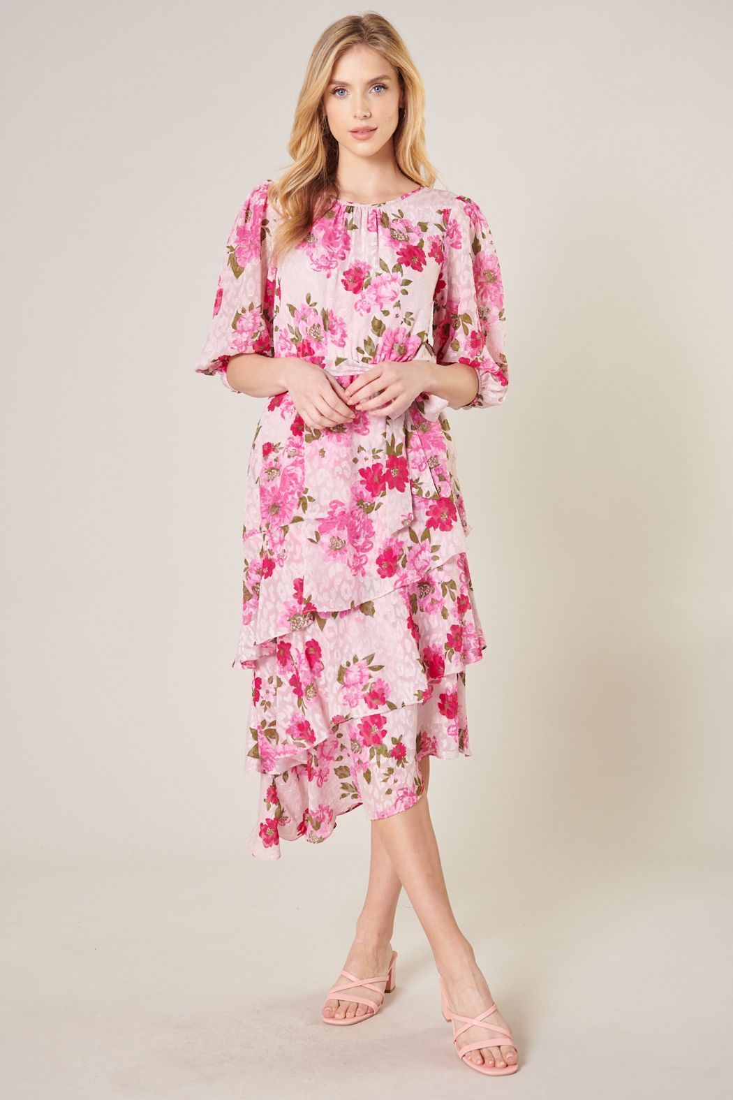 Pink floral midi dress with cascading asymmetrical ruffles and feminine silhouette