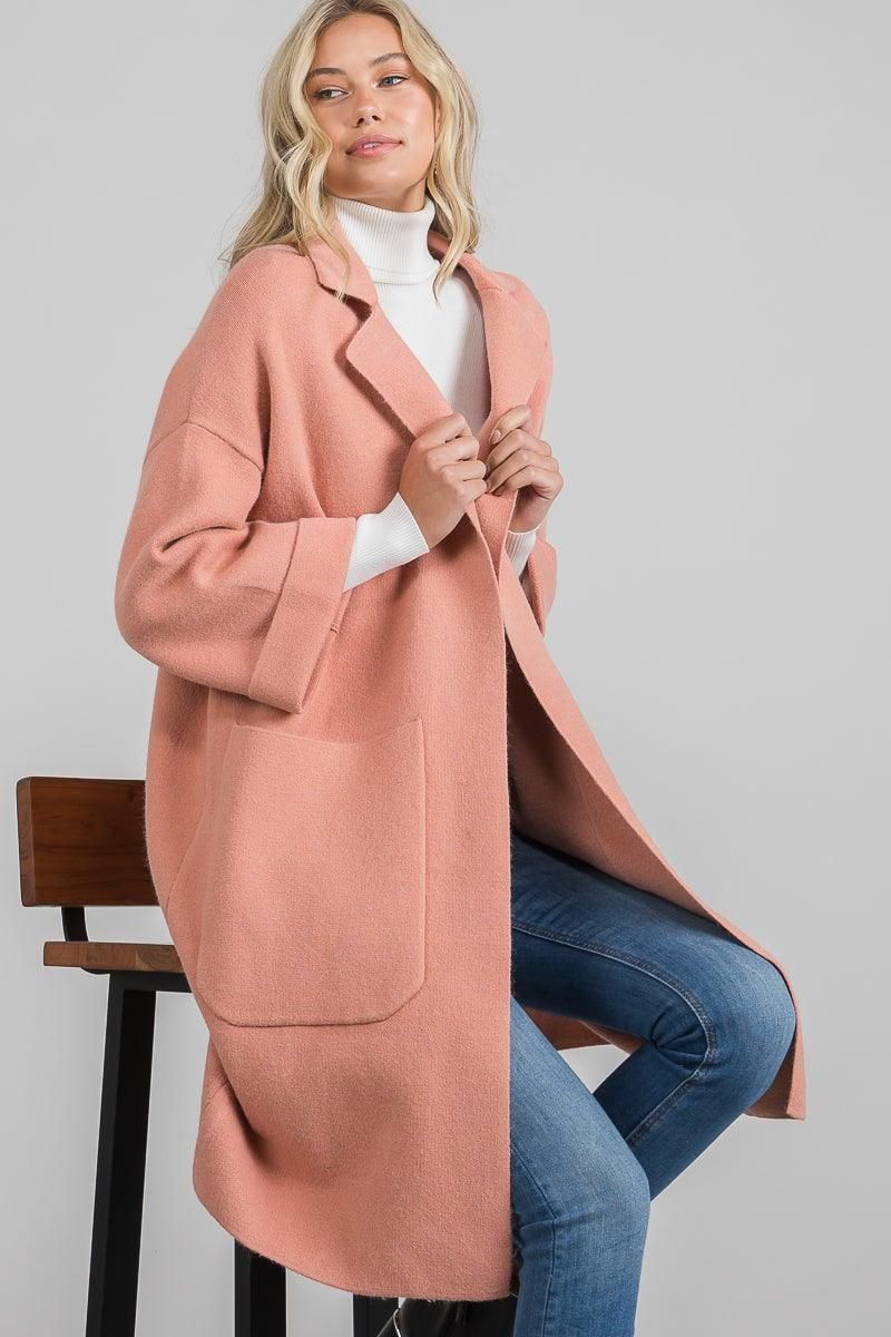 Model wearing a mauve pink Allie Rose coat featuring long sleeves, a fold-over collar, and two oversized front pockets