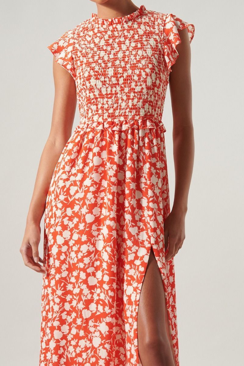 Close-up of smocked bodice, high ruffle neckline, and cherry red floral print on midi dress