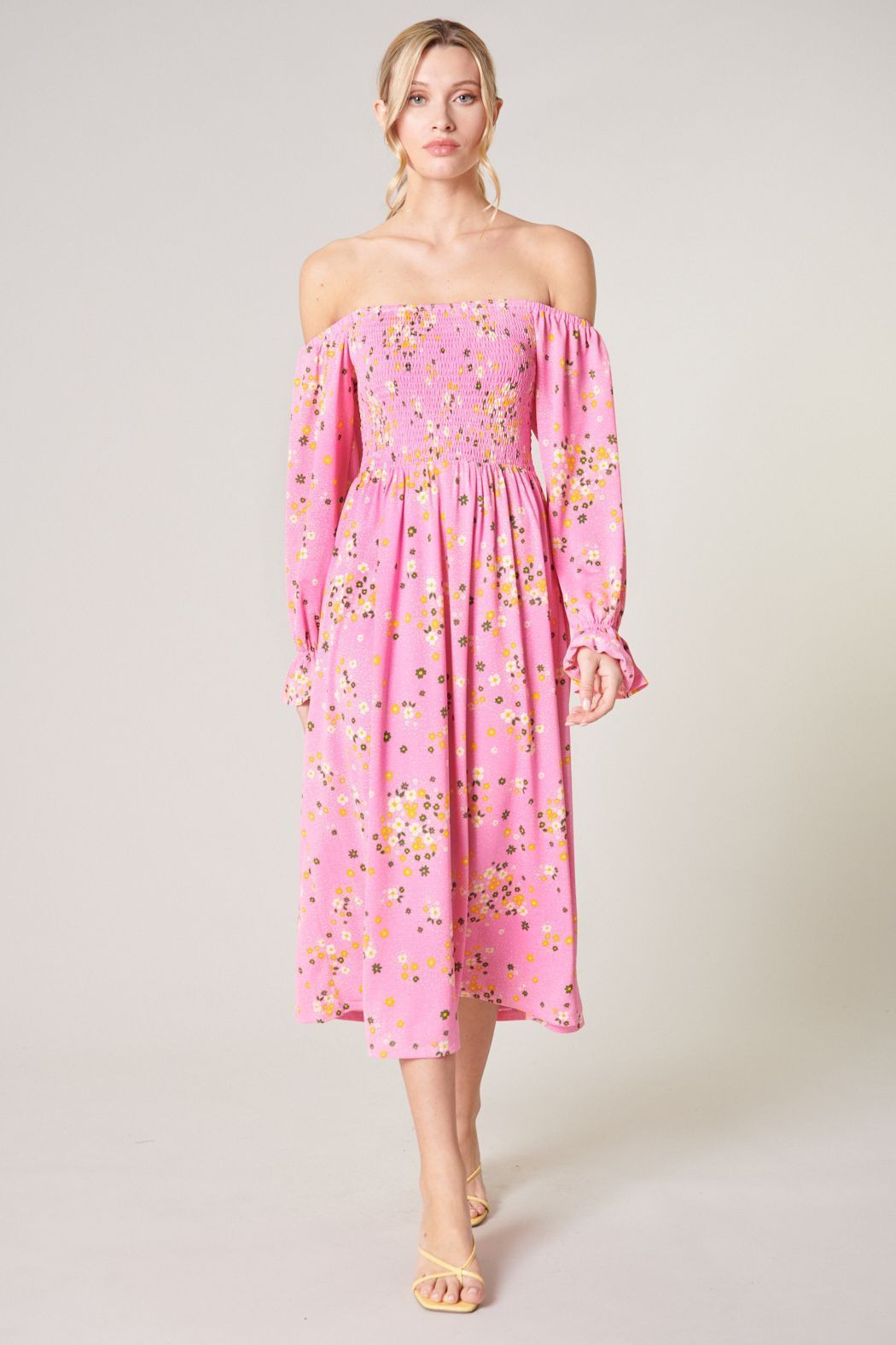 Pink floral smocked midi dress with romantic flowing skirt front view