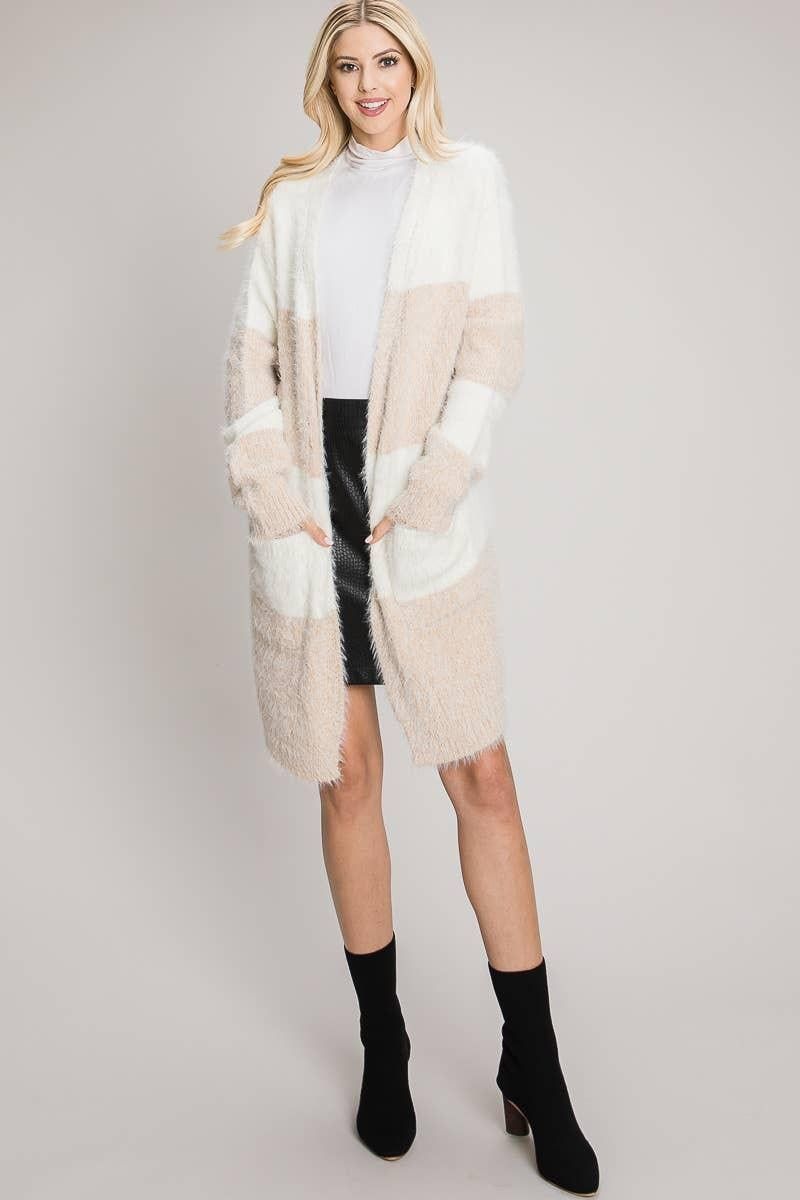 Longline Tan and ivory cardigan styled over a white top and black skirt with ankle boots.