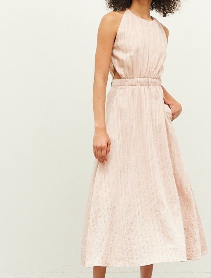 Side profile of minimalist neutral-toned dress with relaxed silhouette and pockets