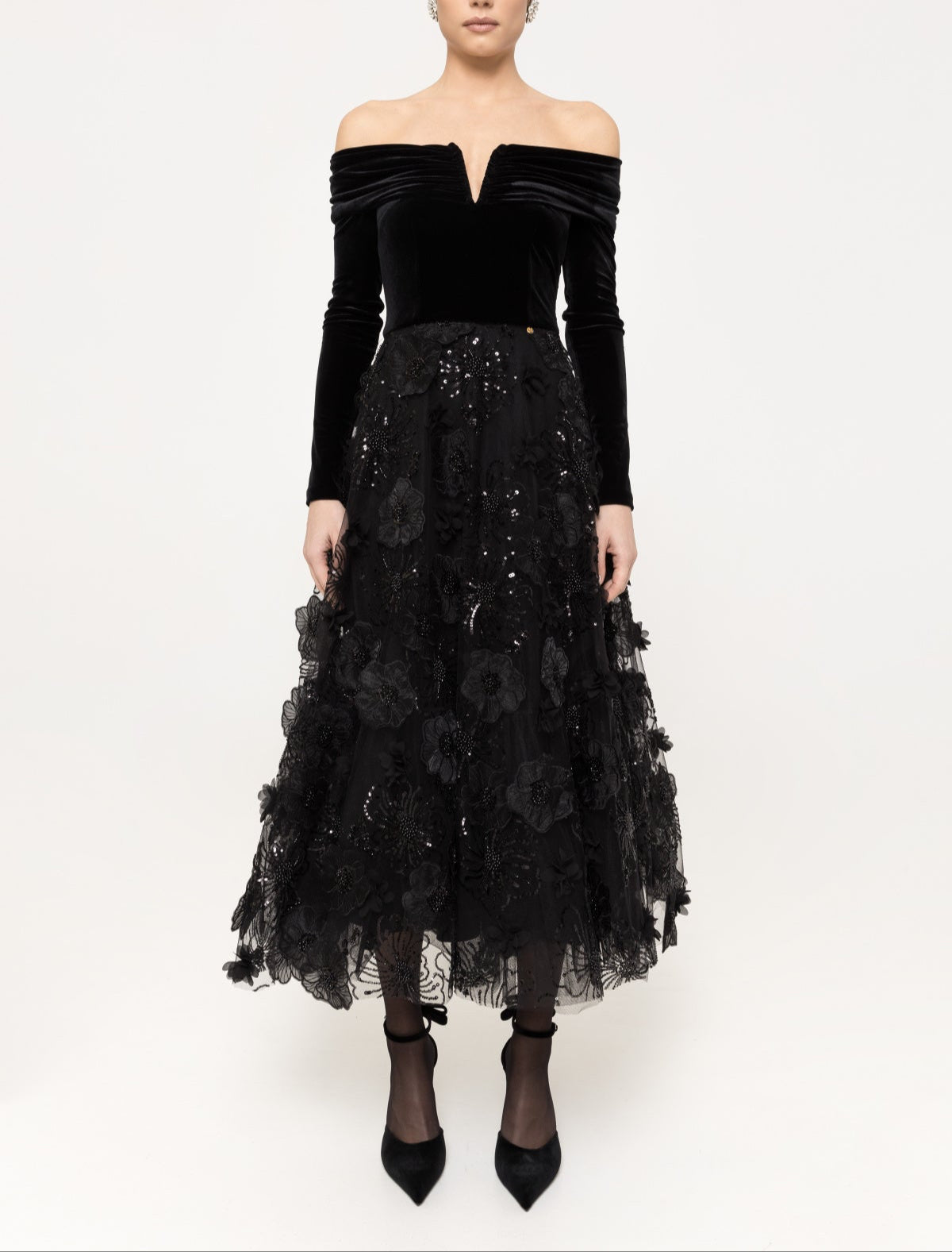 Black off‑shoulder velvet midi dress with V‑notch and 3D floral tulle skirt.