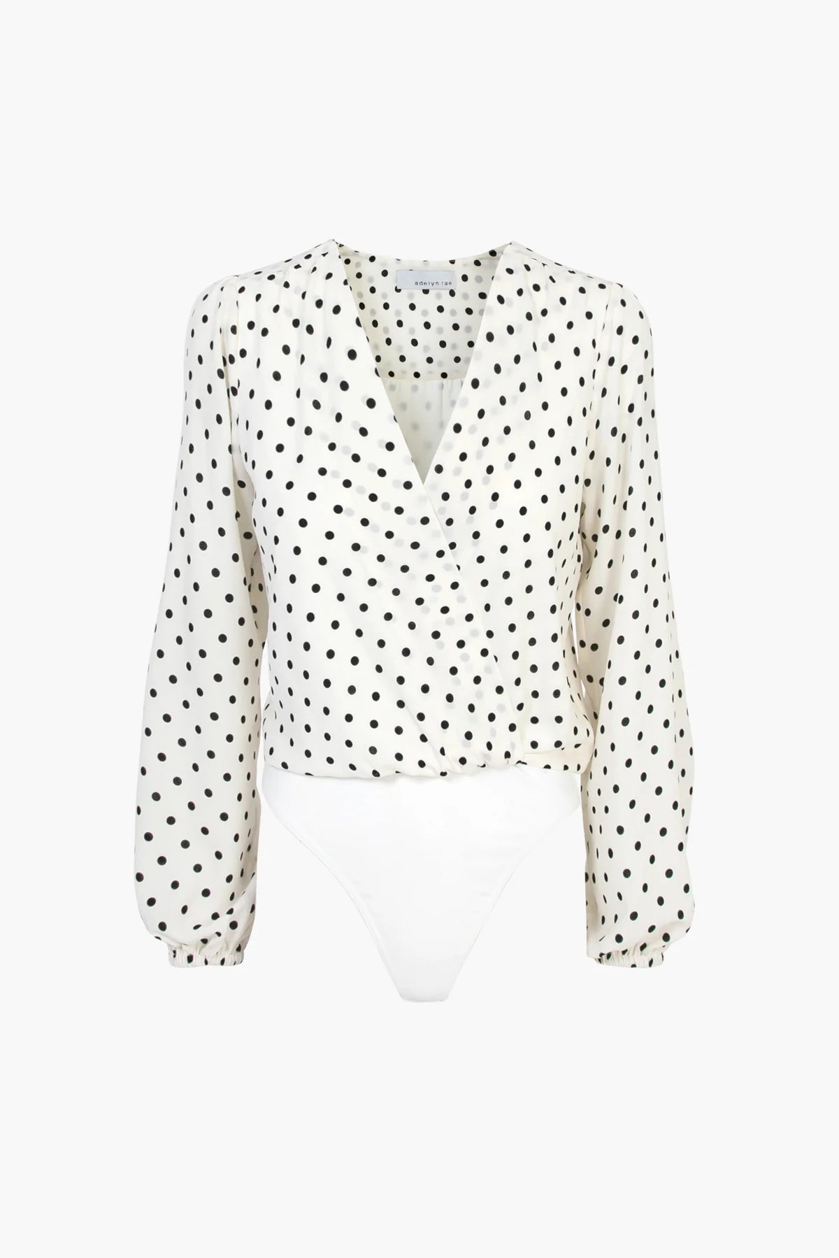 Adelyn Rae Afterhour bodysuit with a deep v-neckline and long sleeves, featuring a classic black polka dot print on a white background
