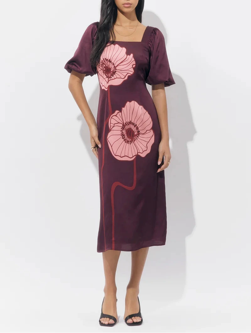 Woman wearing the Alena Puff Sleeve Poppy Maxi Dress in burgundy with oversized pink poppy print, showing the square neckline and front silhouette.