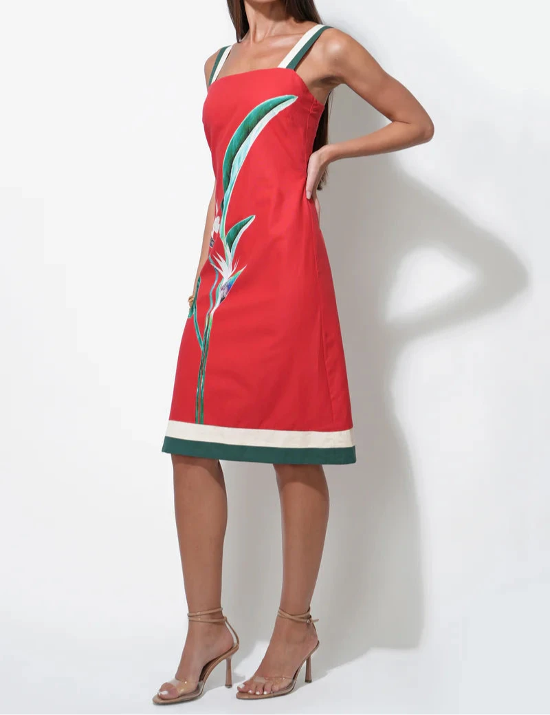 Woman wearing a red dress with Bird of Paradise floral design sleeveless midi dress.