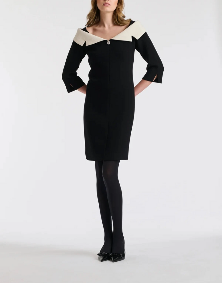 Front view of a model wearing the Weill Paris wool crepe Bardot neck dress in black, featuring an off-the-shoulder Bardot neckline in contrasting ivory and a knee-length hemline.