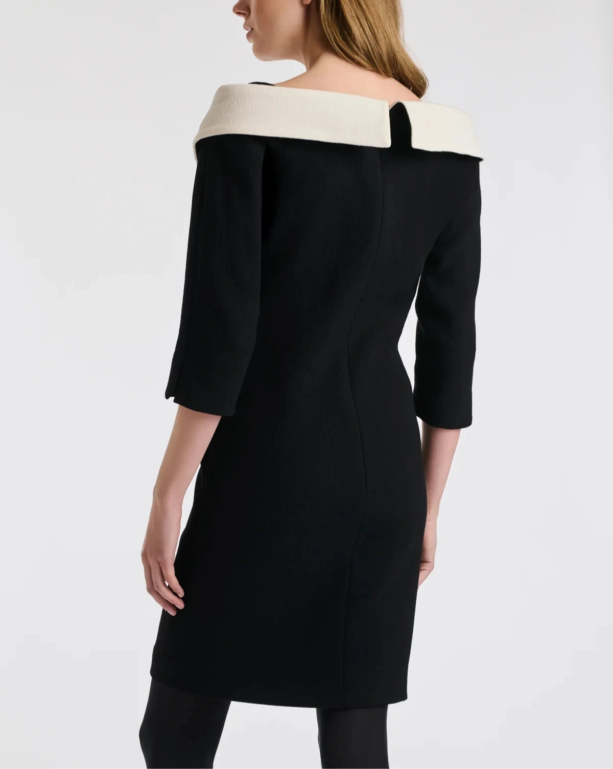 Close angled view of Weill Paris black sheath dress showing ivory Bardot neckline, tailored fit, 3/4 sleeves.