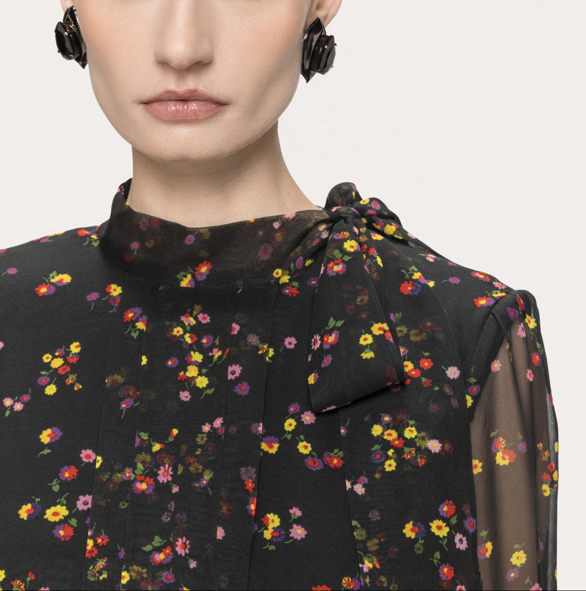 Close-up of the high neckline and asymmetric shoulder bow on the NISSA black floral silk midi dress