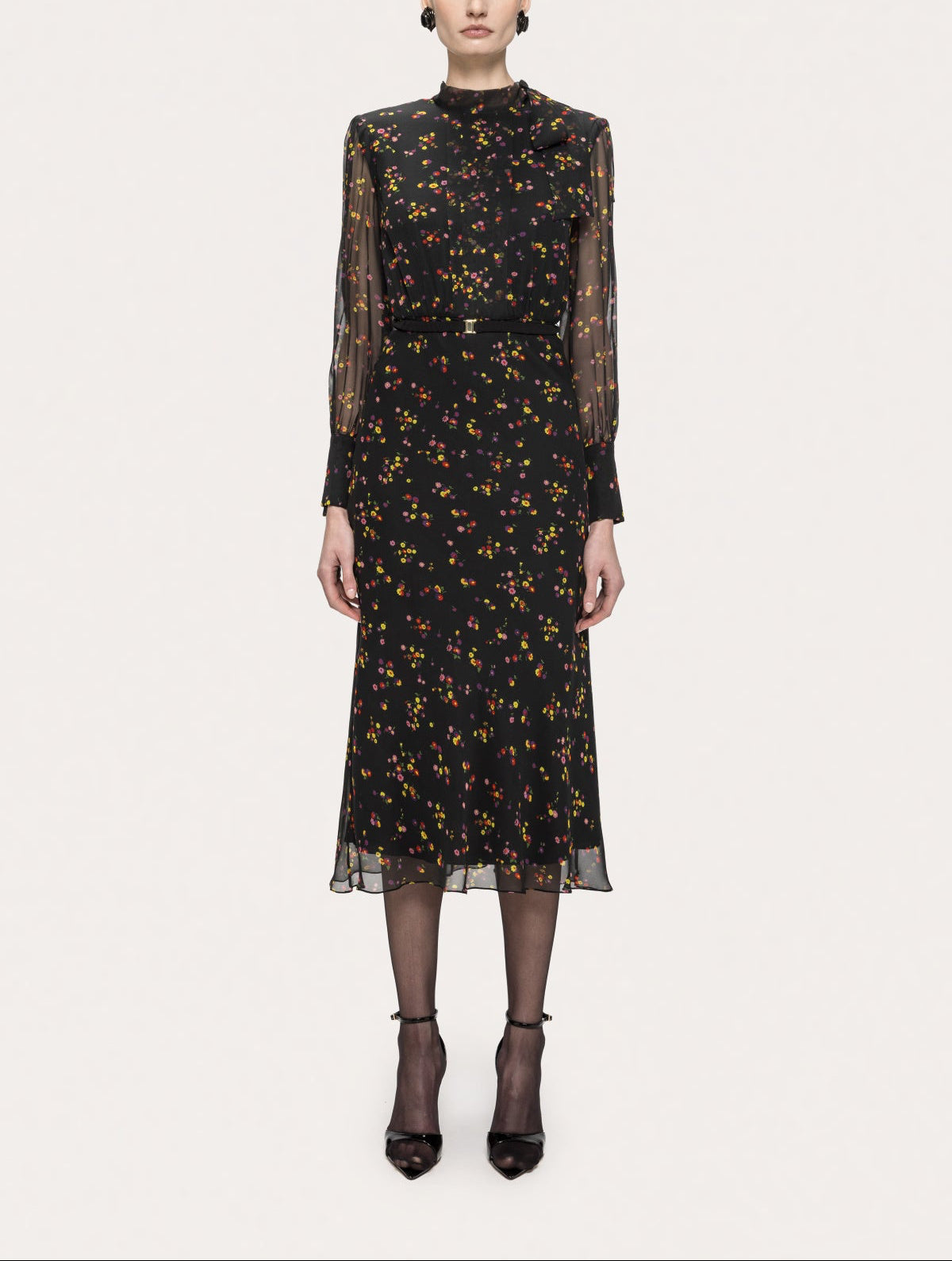 Model wearing the NISSA black floral silk midi dress with sheer long sleeves and belted waist, front view