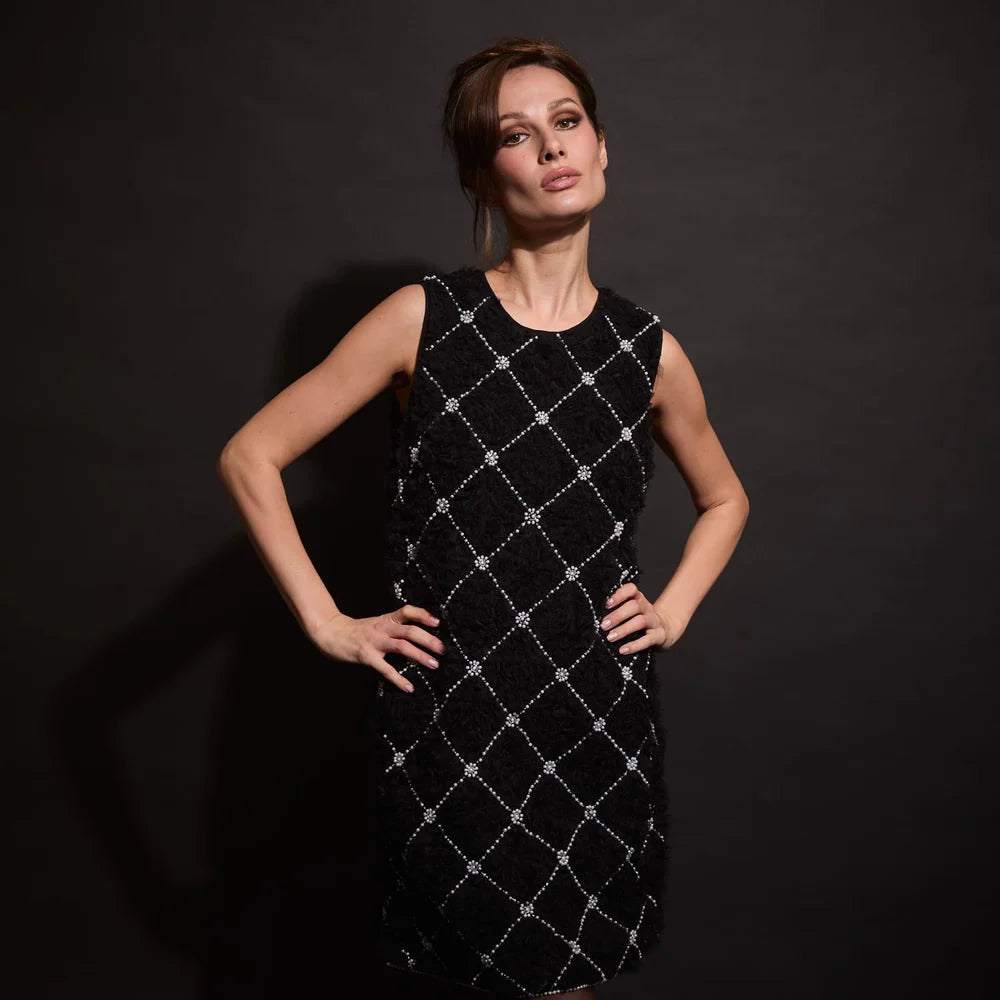 close up view of black sleeveless dress with diamond pattern