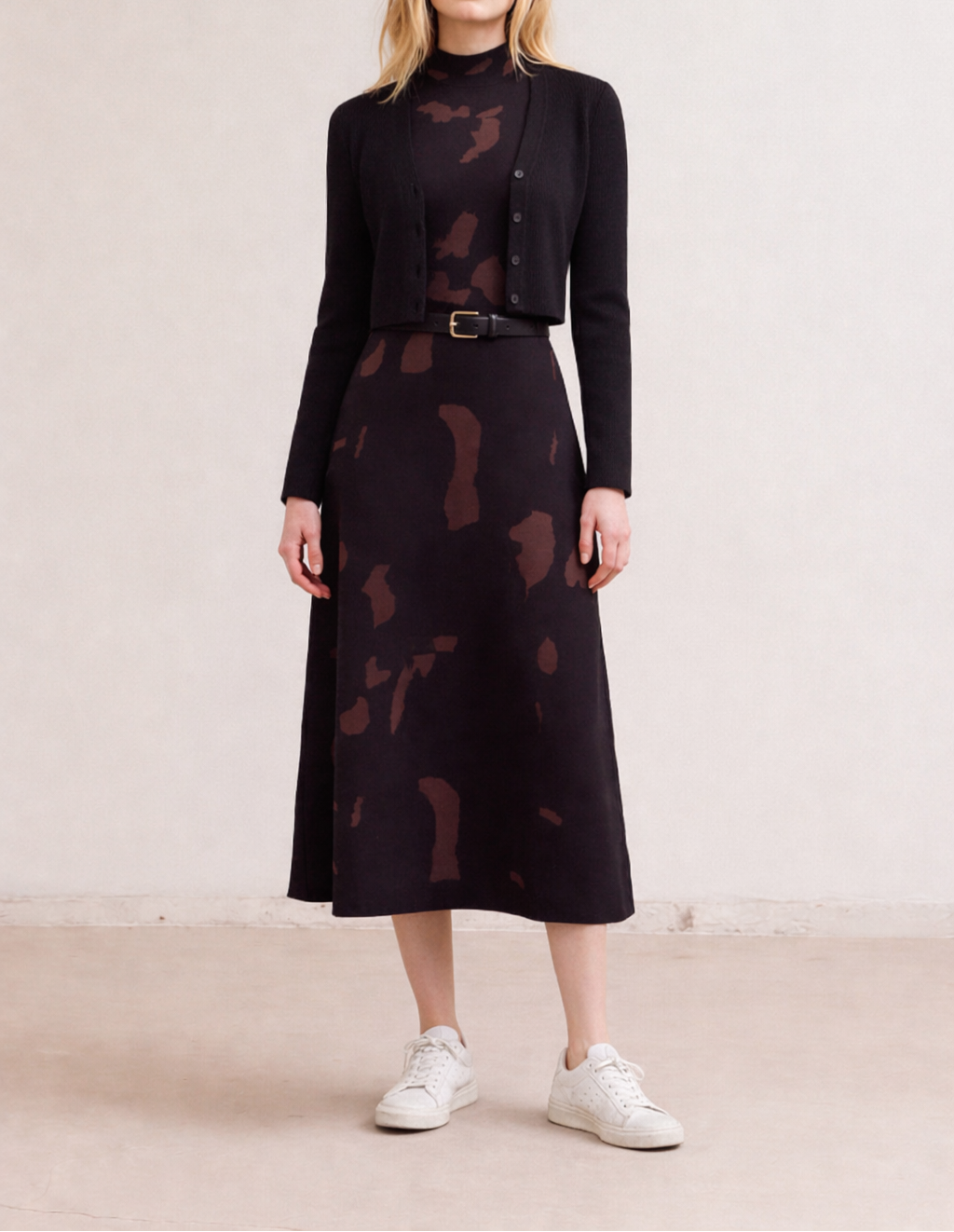 Woman wearing a black patterned fitted knit maxi dress with a matching jacket on a plain background