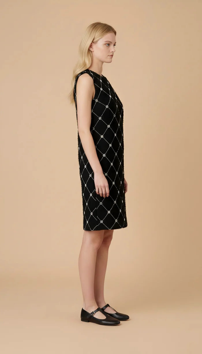 side view of model wearing black sleeveless dress with diamond pattern