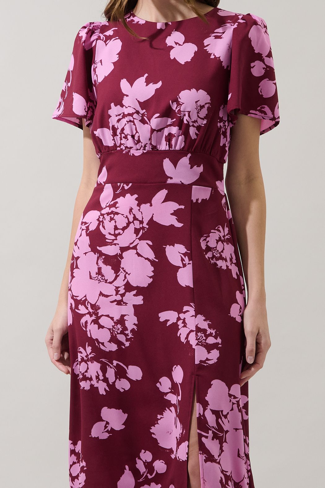 Close-up of pink peony print, round neckline, gathered shoulders and smooth front waistband on the Bloom dress.