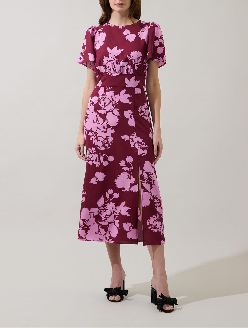 Front view of the Bloom burgundy and pink peony floral midi dress with short flutter sleeves and a side slit.
