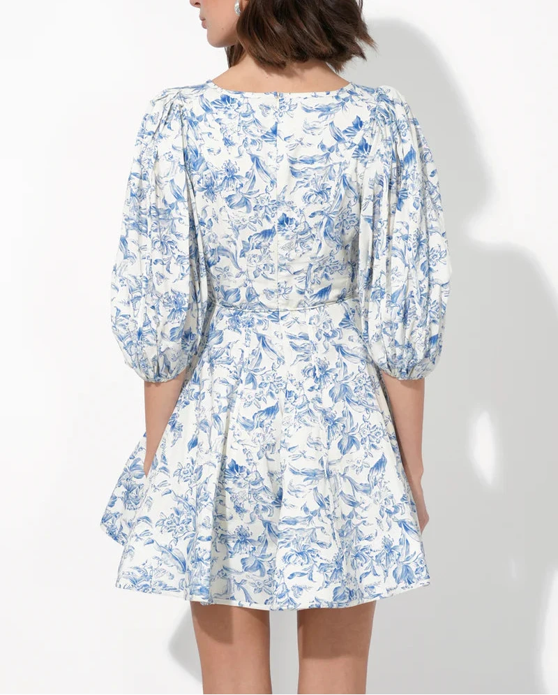 Back view of blue‑and‑white floral mini dress with elastic‑cuff sleeves, fitted waist and flippy A‑line hem