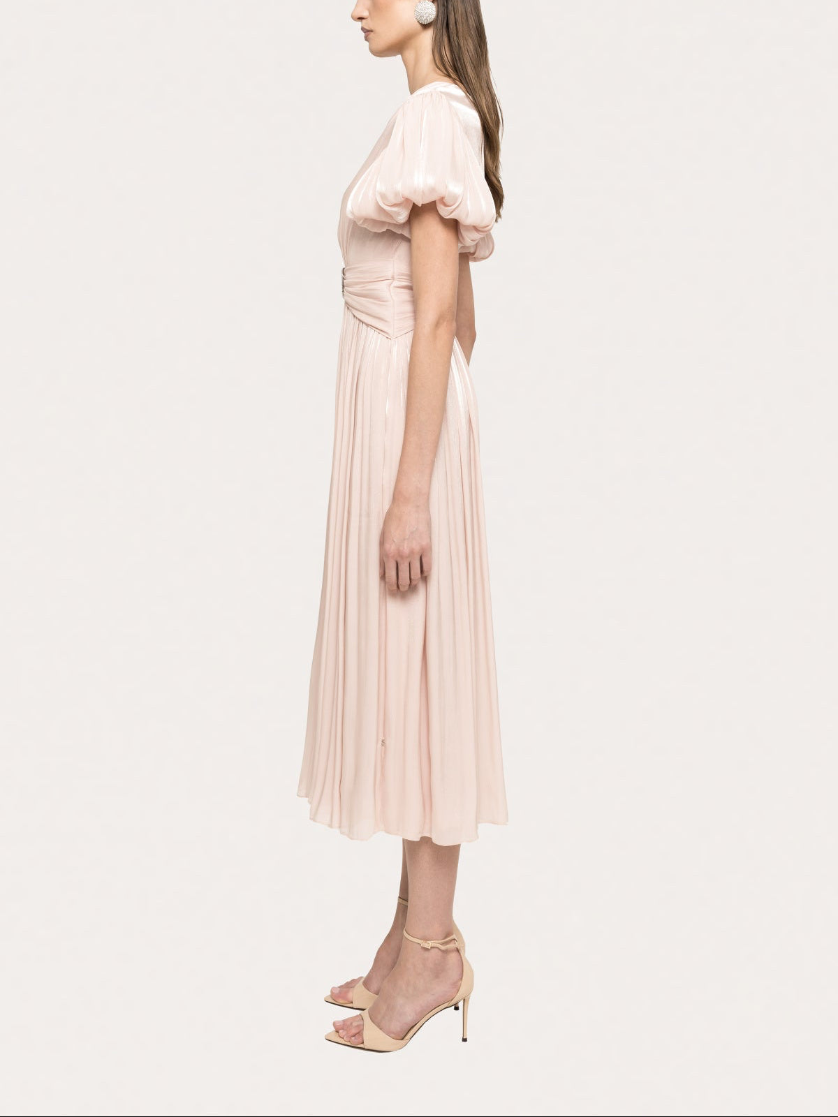 Side view of blush pleated midi dress with voluminous puff sleeves and fitted waist