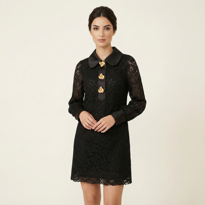 Woman wearing a black lace dress with gold buttons on a beige background