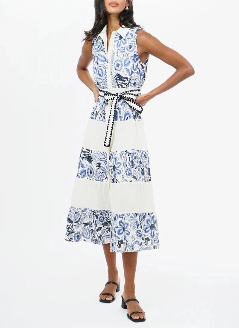 Model wearing the Ethena Embroidered Sleeveless Shirt Midi Dress by Adelyn Rae – a white cotton midi shirt dress with blue floral embroidery and a tie waist