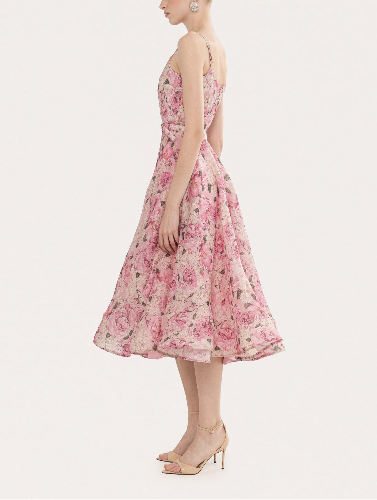 Side view of a pink floral belted midi dress with a full flared skirt and adjustable spaghetti straps