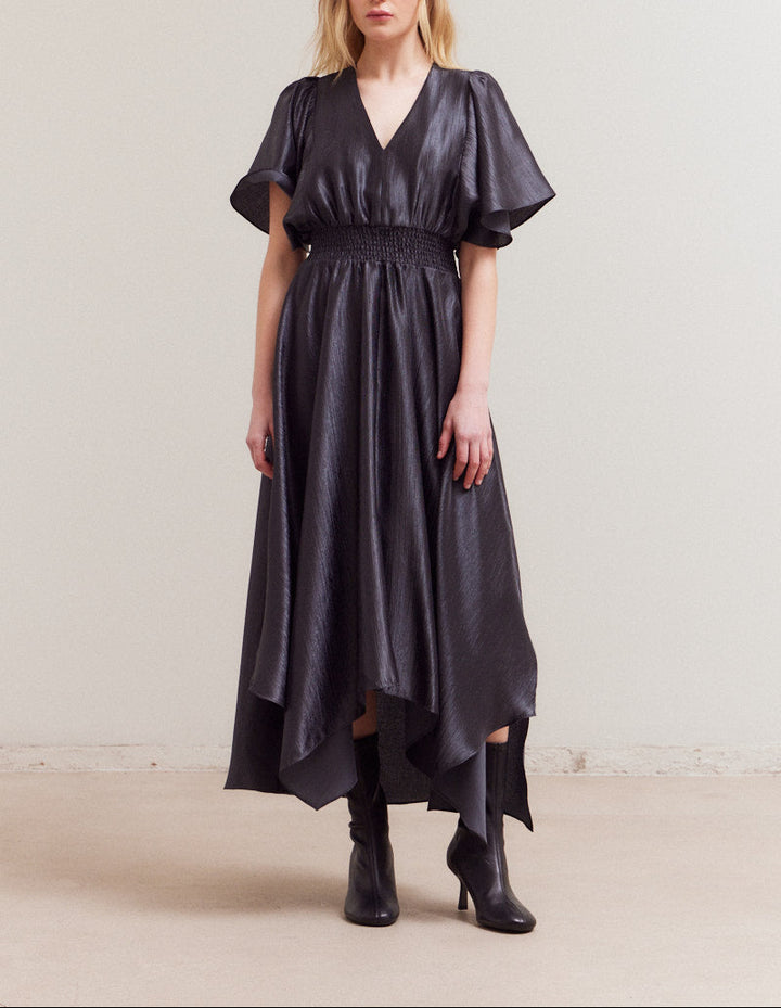 Front view of model wearing midnight satin maxi dress with flutter sleeves and handkerchief hem.