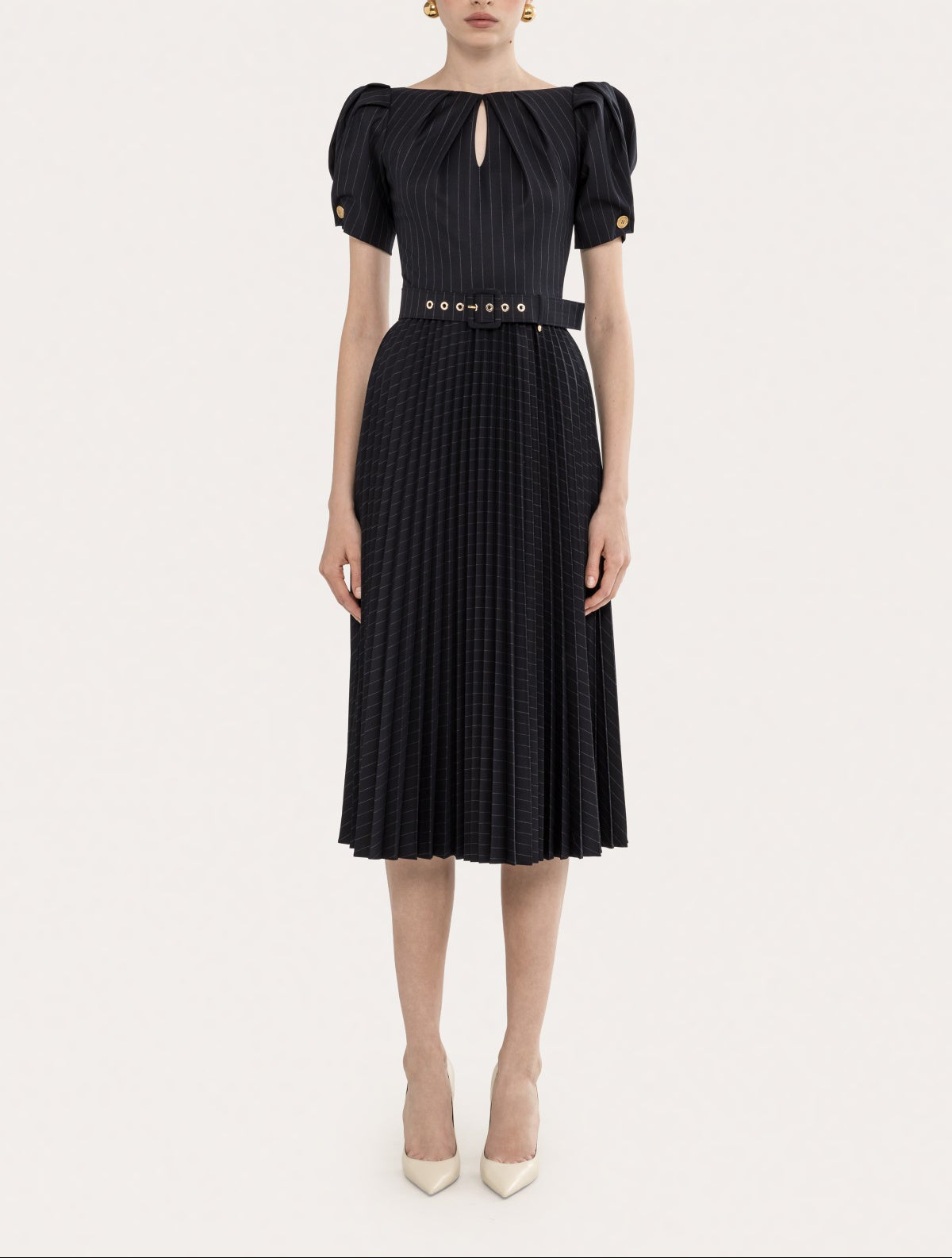 Model wearing a black pinstripe puff sleeve pleated midi dress with belt, keyhole neckline, and fitted waist