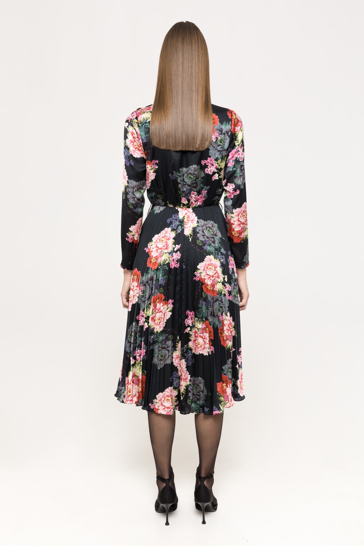 Back view showing full floral print and pleated midi skirt on black base with long sleeves and fitted waist