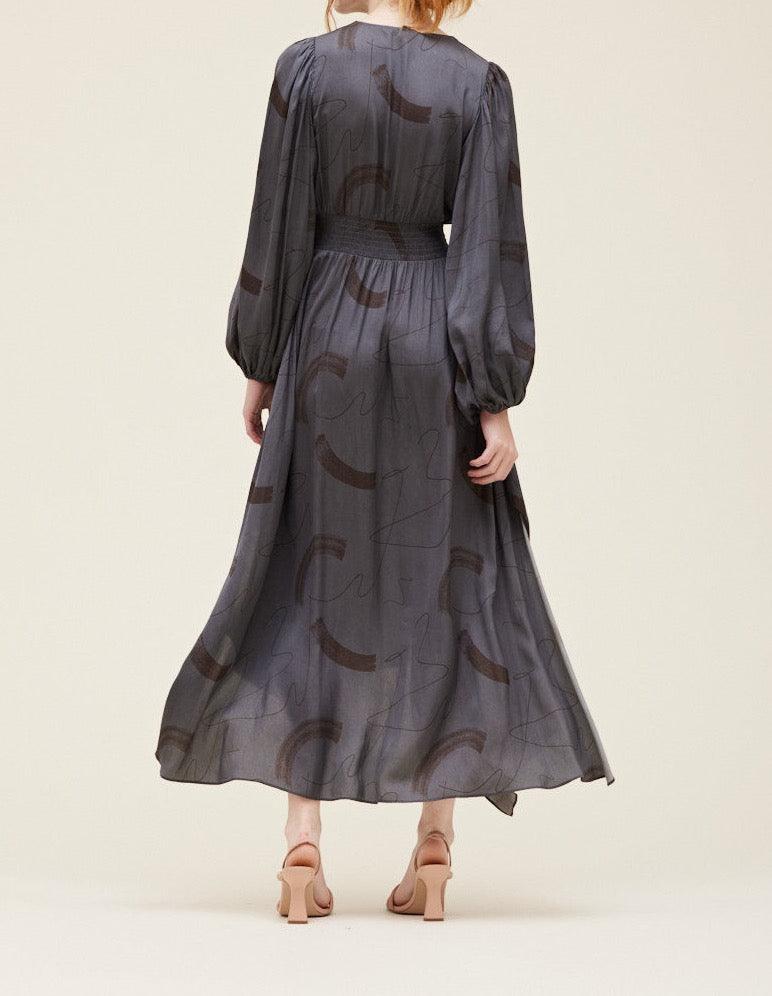 Back view of the Grade & Gather Slate satin maxi dress showing the covered back, smocked waist and flowing skirt.