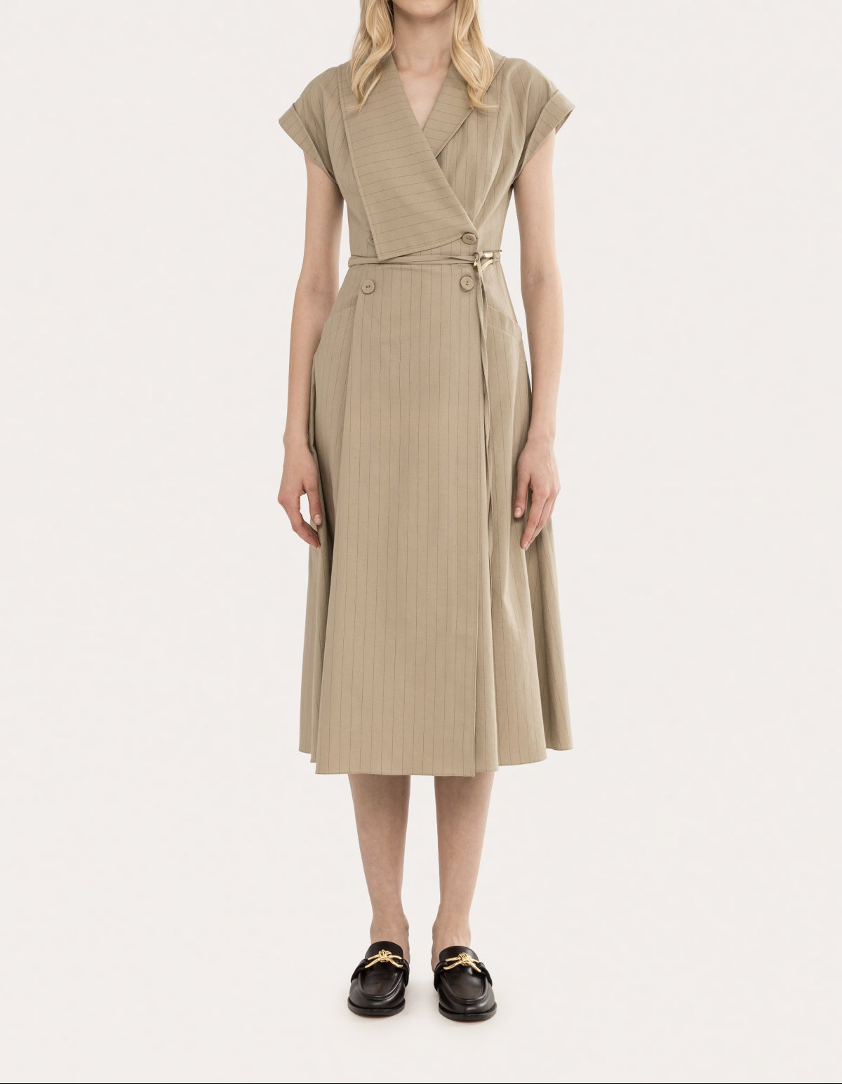 Model wearing a beige pinstripe cotton-linen wrap midi dress with cap sleeves, deep V neckline, defined waist, and midi-length skirt